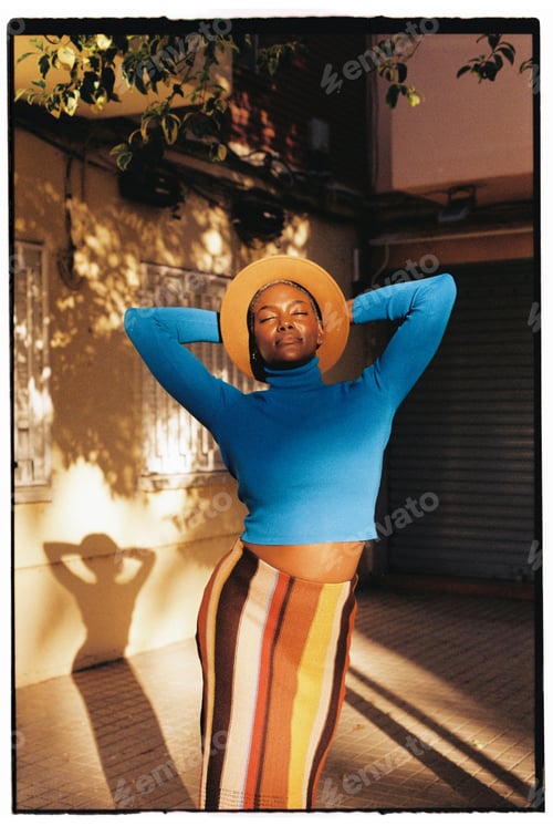Preview: Positive black female standing with raised arms on street