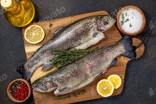 Preview: Fresh fish trout and ingredients for cooking. Raw fish trout with spices and herbs