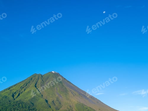 Preview: Green mountain under clear blue sky with moon