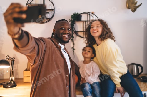 Preview: Cheerful multiethnic family taking selfie together