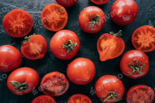 Preview: Top view of highly detailed red tomatoes on black background being wet