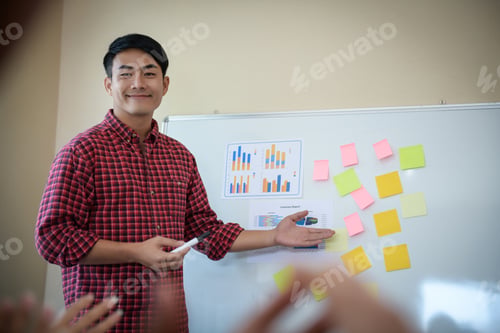 Preview: Handsome young man standing near whiteboard and presentation perfect planning business.