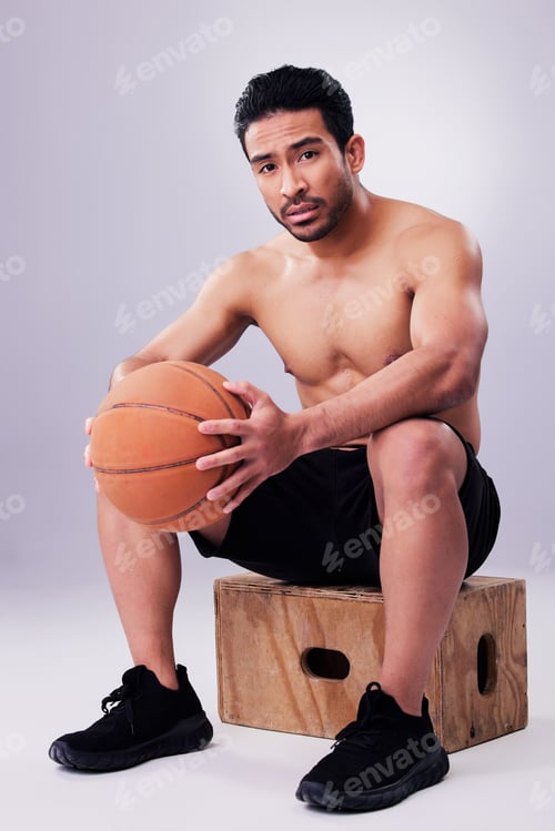 Preview: Portrait, fitness and basketball with a man on a box in studio on a gray background for training or