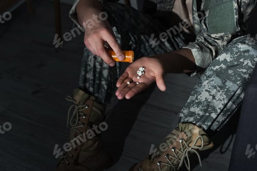 Preview: Cropped view of military veteran pouring pills on hand while suffering from emotional distress at