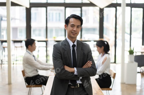 Preview: Professional businessman standing with arms crossed in the meeting room.