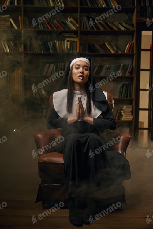 Preview: Woman in nun dress smoking cigarette sitting with folded hands in pray position