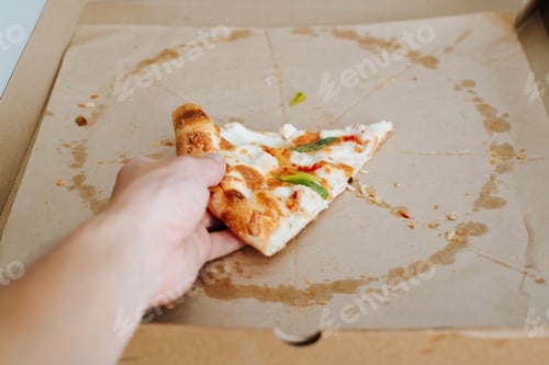 Preview: Eaten pizza. Close-up of a hand taking the last one slice of cheesy pizza from a cardboard box
