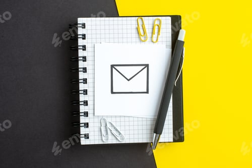 Preview: Top view of message drawing on white blank and pen on notebook on dark color yellow background with