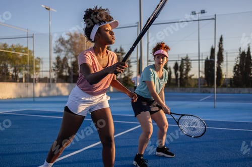 Preview: Female tennis players preparing to receive serve on blue court