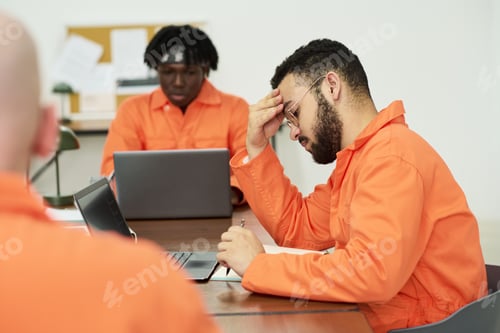 Preview: Young Man Studying with Laptop among Incarcerated Students in Classroom