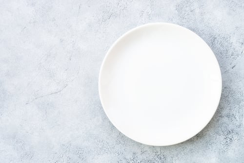 Preview: White plate and napkin at stone table.