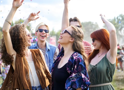Preview: Group of caucasian young people dancing among confetti on music festival