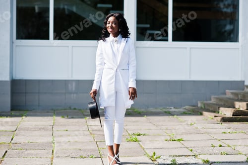 Preview: Elegant Woman in White Suit Stands Outdoors
