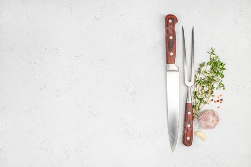 Preview: Kitchen knife and meat fork with garlic, herbs and spices on a light textured surface
