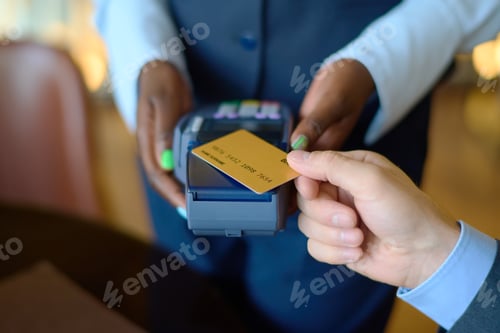Preview: Manager holding payment terminal while man with credit card paying for purchase