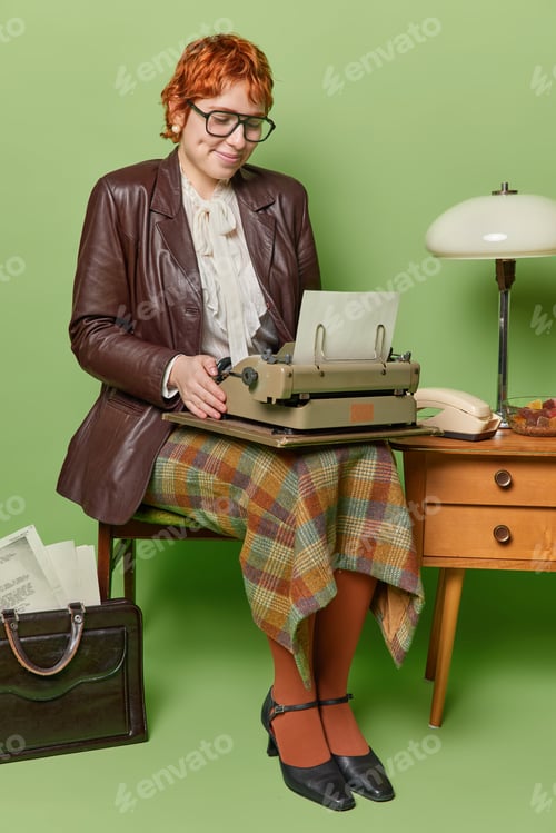 Preview: Retro business concept. Pleased redhead woman with short haircut works with manual old typewriter