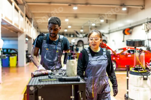 Preview: Mechanics working in busy auto repair shop