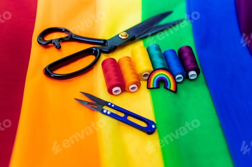 Preview: multi-colored pieces of fabric and a threads on the table preparation for the ride parade lgbt