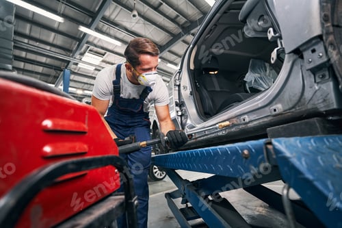 Preview: Repairman peening car with tool for removing dents