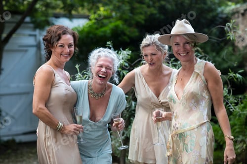 Preview: Elegant mature women enjoying champagne in urban garden