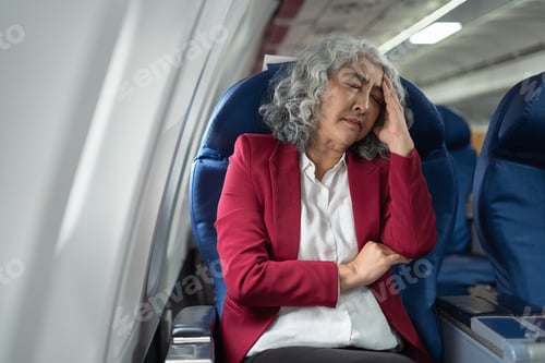 Preview: Tired asian businessman with headache feeling sick while sitting in the airplane