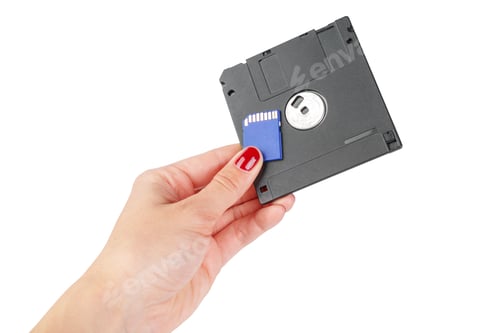 Preview: Two types of computer storage being held in one hand in a clear setting