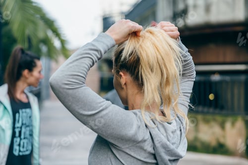 Preview: Woman Putting Hair in Ponytail Outdoors