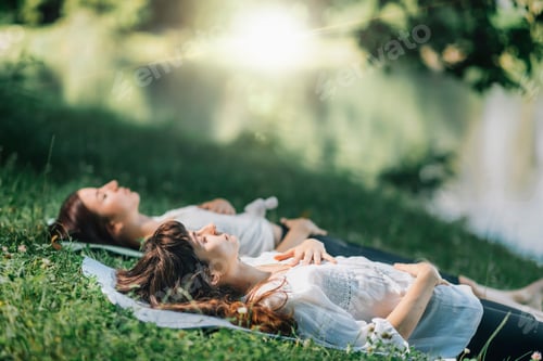 Preview: Women Relaxing on Blanket in Grassy Area