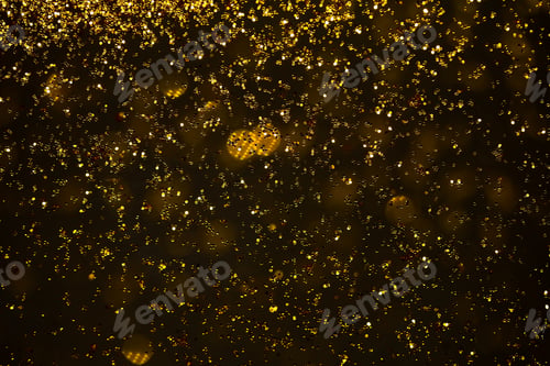 Preview: Defocused Golden Particles Glittery against Dark Background with Copy Space.
