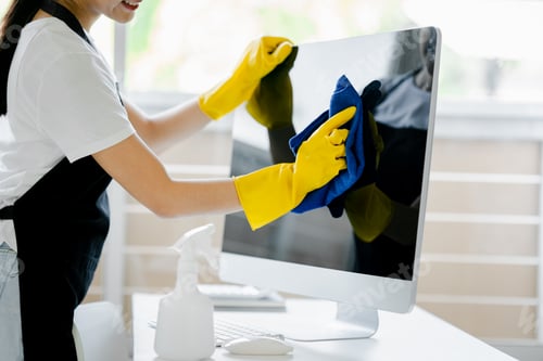 Preview: Young woman using a computer cleaning cloth to disinfect the officeoffice cleaning staff cleaning ma