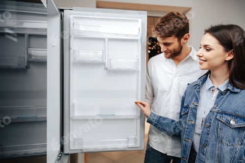 Preview: Young couple selecting new refrigerator in household appliance store