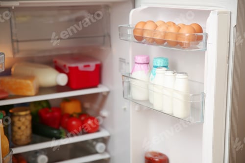 Preview: Open refrigerator with fresh food on shelves