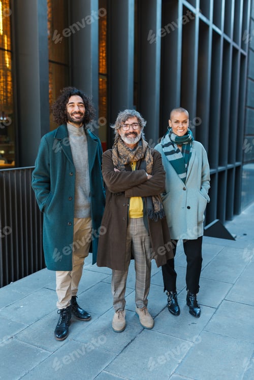 Preview: Cheerful Hispanic colleagues looking at camera oncity street
