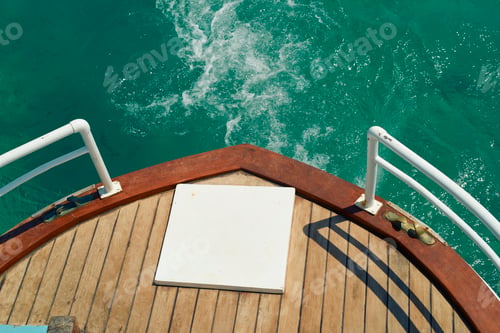 Preview: Boat prow over turquoise ocean water with wooden deck and white railings. Mykonos, Greece