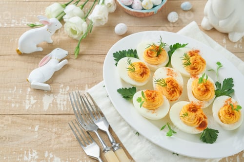 Preview: Easter stuffed eggs. Traditional Easter brunch or dinner with stuffed eggs with paprika, carrot cake