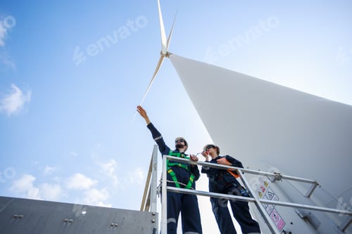 Preview: Team engineer wind turbine worker safety uniform survey discuss operational planning windmill