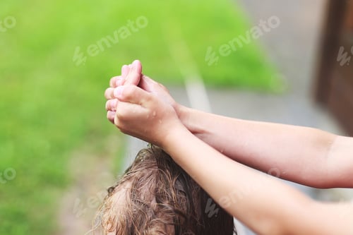 Preview: brother and sister play in rainy weather. wet hands close.