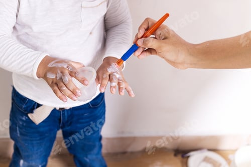 Preview: Hispanic mom paints the child's hand with white paint