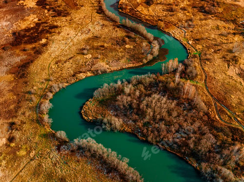Preview: Aerial view of turquoise winding river and golden autumn