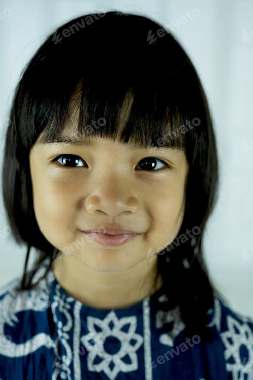 Preview: The portrait of a little child girl stands smiling looking into the camera's