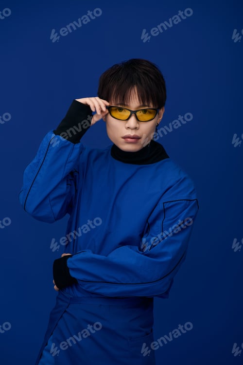 Preview: Stylish young asian man poses confidently in vibrant blue attire against a rich backdrop