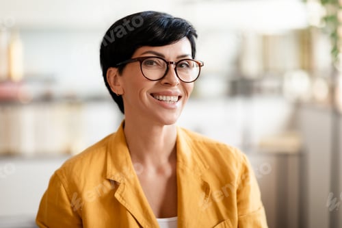 Preview: Portrait of happy middle aged woman smiling at camera indoors