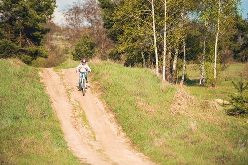 Preview: smiling little girl riding a bike