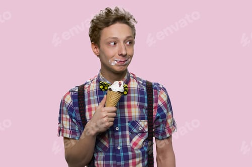 Preview: Funny boy holding ice cream on color background.