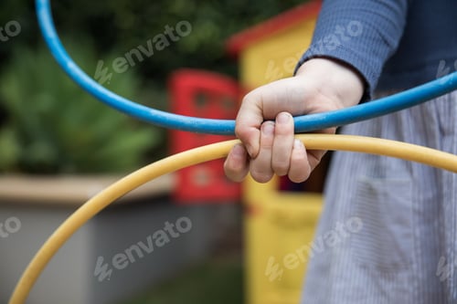Preview: Young girl child holding a hula hoop outdoors playing having fun