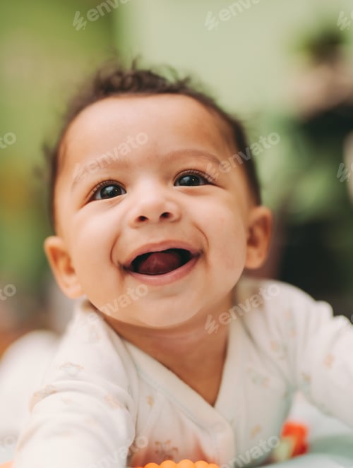 Preview: Portrait of cute happy smiling mixed race toddler boy in white outfit at home in living room