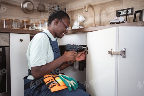 Preview: Handyman repairing kitchen cabinet using cordless screwdriver