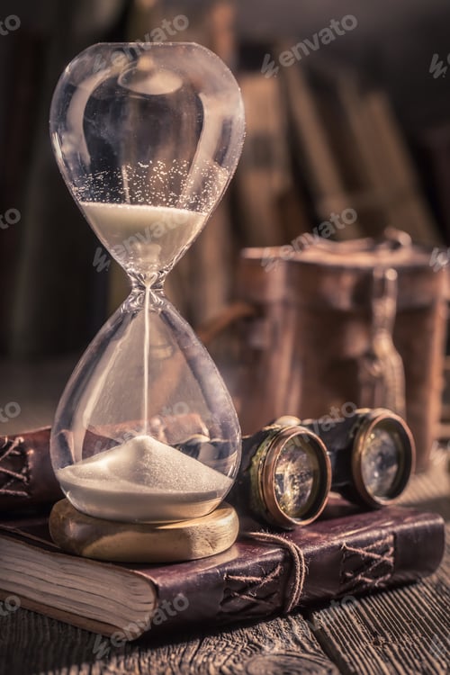 Preview: Old hourglass and journal with binocular and compass