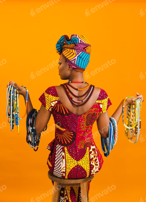 Preview: Afro look. Afro girl from behind on the orange/yellow background.