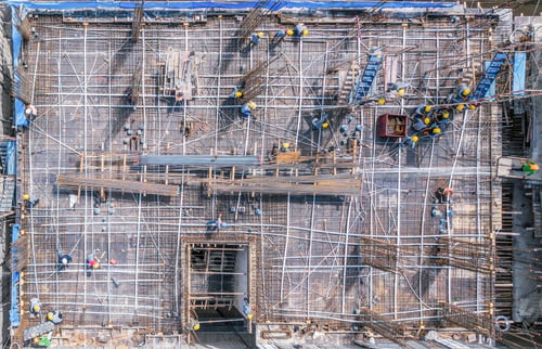 Preview: Aerial view of busy industrial construction site workers working. Development high rise building.